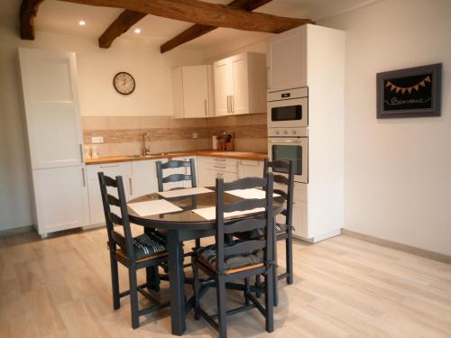 a kitchen with a table and chairs in a room at Gite de charme Les Buissonnets in Plesder