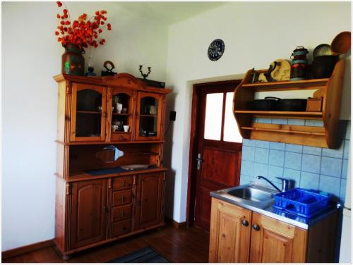 kuchnia z drewnianymi szafkami, umywalką i oknem w obiekcie Gospodarstwo Agroturystyczne U KRYSTYNY Krystyna Kurczab w Limanowej