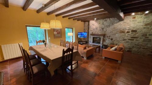 a dining room with a table and a stone wall at La Borda del Tío Nicolás - Selva de Irati in Aribe