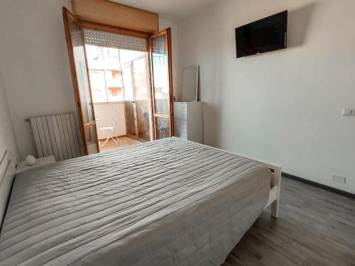 a bedroom with a large bed and a television at Finestra sul mare in Lido di Fermo