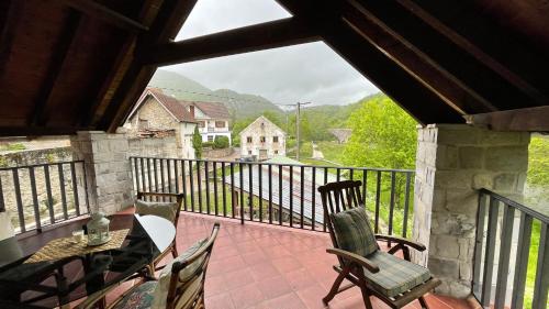 a balcony with a table and chairs and a view at La Borda del Tío Nicolás - Selva de Irati in Aribe