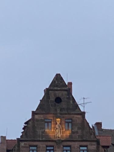a building with a statue on the top of it at Hotel Deutscher Kaiser in Nürnberg