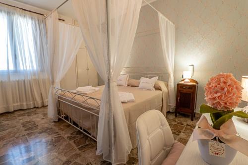 - une chambre avec un lit avec des rideaux et une table dans l'établissement NONNA VALERIA, à Diso