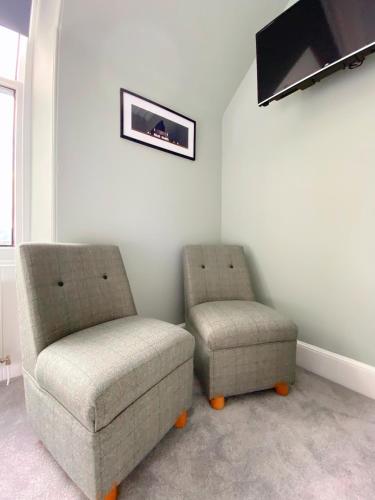 two chairs and a couch in a living room at Cairngorm Guest House in Aviemore
