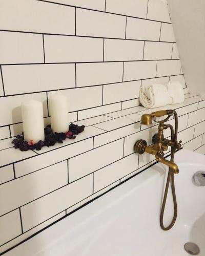 a bath tub with candles on a white tiled wall at Siedlisko Besarabka in Czernikowo