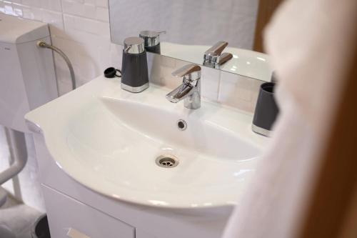 a white sink in a bathroom with a mirror at Bonaca in Rogotin