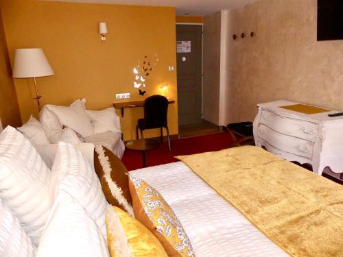a living room with two beds and a table at Le Chapeau Rouge in Lusignan