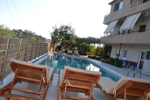 - deux chaises et une piscine en face d'un bâtiment dans l'établissement Ksamil Apartments, à Ksamil