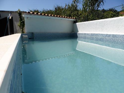 a pool of water next to a white wall at Beautiful Country House&Romantic Garden in Sintra
