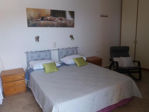 a bedroom with a large bed and a chair at Melina's Sunset in Myrties