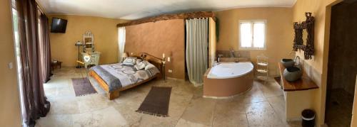 a bedroom with a bed and a tub and a sink at Maison au Castellet in Le Castellet
