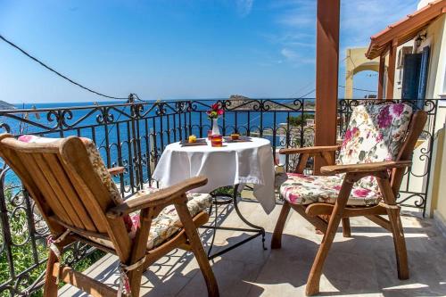 a table and two chairs on a balcony with the ocean at Melina's Sunset in Myrties