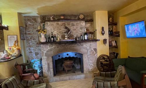a living room with a stone fireplace with couches at Agriturismo Il Pozzo in Polla