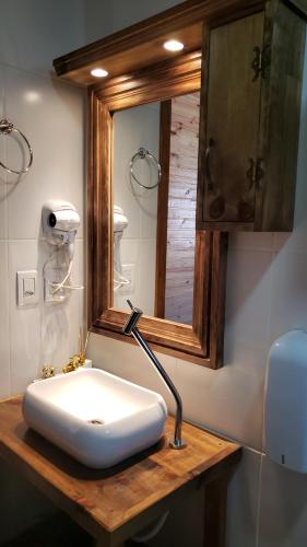 a bathroom with a white sink and a mirror at Cabana Frio da Serra in Urubici