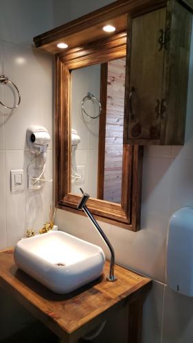 Un baño con un lavabo blanco y un espejo. en Cabana Frio da Serra, en Urubici