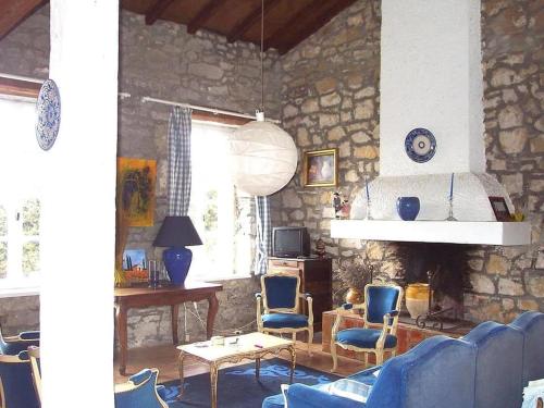 - un salon avec des chaises bleues et un mur en pierre dans l'établissement Villa L'ESTRADE, à Montréal