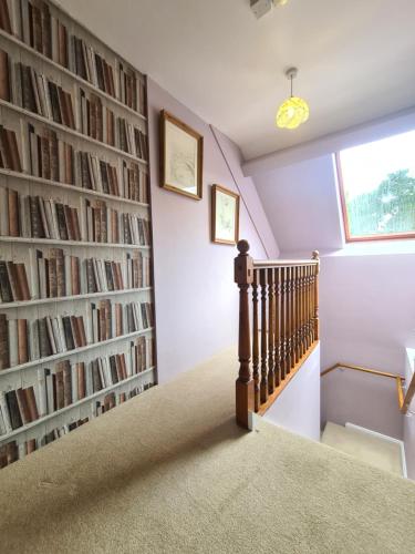a room with a staircase with a wall of books at Broom Hall Country Hotel in Saham Toney