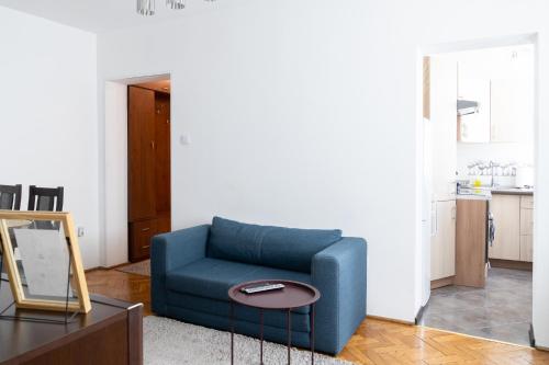 um sofá azul numa sala de estar com uma mesa em Własne M-Studio CENTRUM parter em Konin