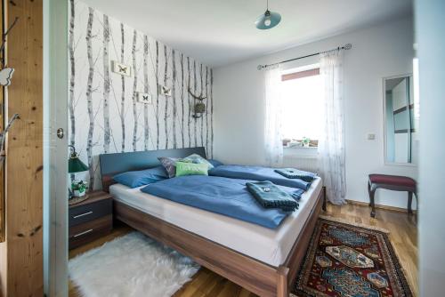 a bedroom with a bed with blue sheets and a window at Hussi's Home in Großenhain