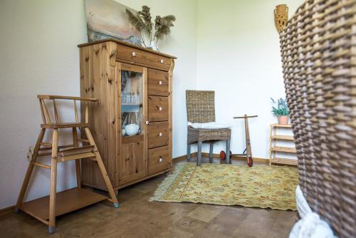 a wooden cabinet in a living room with a chair at Hussi's Home in Großenhain