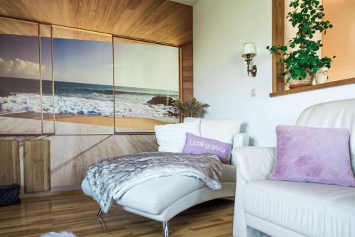 a living room with a couch and a picture of the beach at Hussi's Home in Großenhain