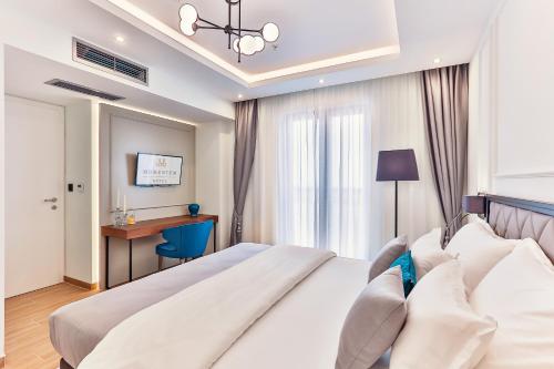 a bedroom with a large white bed and a desk at Boutique Hotel Momentum by Aycon in Budva