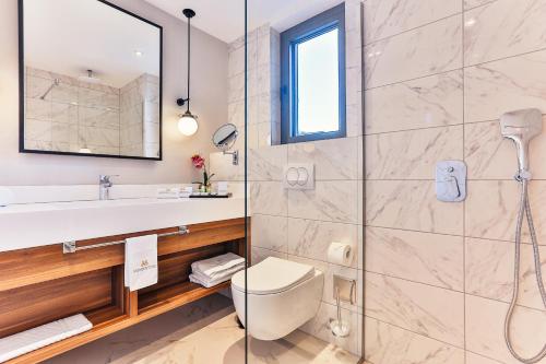 a bathroom with a shower and a toilet and a sink at Boutique Hotel Momentum by Aycon in Budva