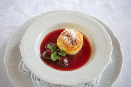 a white plate with a bowl of soup with a pastry at Tourist farm Pri Andrejevih in Narin