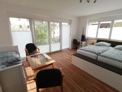 um quarto com uma cama, uma mesa e janelas em 60qm 2 Raum Wohnung nahe dem Stadtzentrum em Rostock