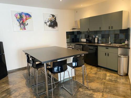 a kitchen with a table and chairs in it at 021 CHIC & COSY GRAND APPART 84m2 HYPERCENTRE WIFI SMART TV NETFLIX in Saint-Étienne
