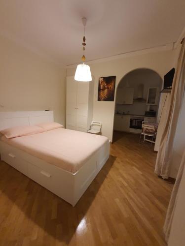 una camera con un letto bianco e una sedia di CASA VACANZA COLOSSEO WHOLE HOLIDAY HOME APARTMENT da PAMINO & PRISCILLA a Roma