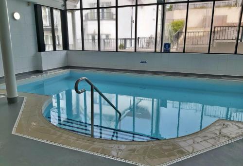 a swimming pool with a hand rail in a building at Finest Retreats - Y Lle Hapus in Tenby