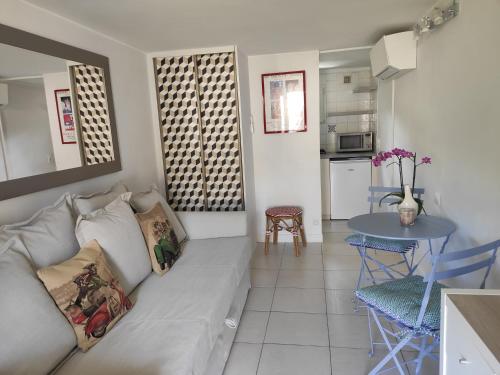 a living room with a couch and a table at La Glycine Tropézienne in Saint-Tropez