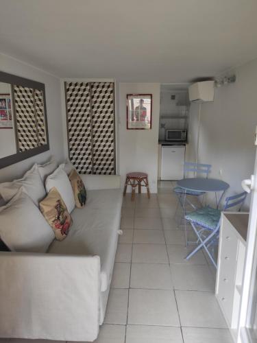 a living room with a couch and a table at La Glycine Tropézienne in Saint-Tropez