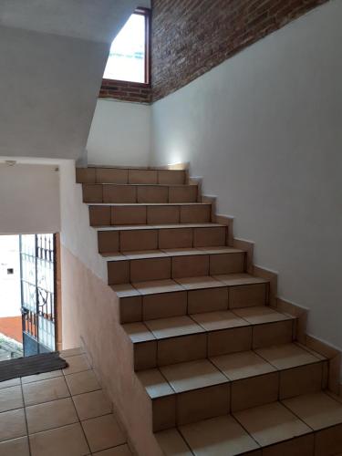 a staircase in a room with a window and a stair case at Taxco de mis amores in Taxco de Alarcón