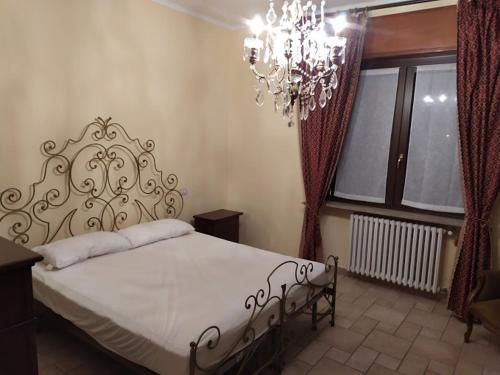 a bedroom with a large bed and a chandelier at Astixio in San Damiano dʼAsti