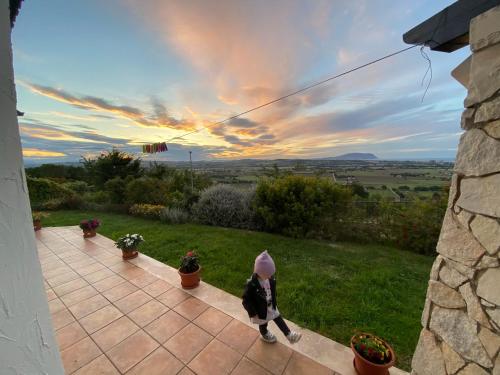 a little girl walking on a patio with the sunset at CASA VACANZA FELICITA' in Porto Potenza Picena