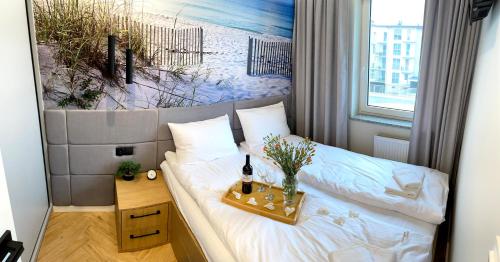 ein Schlafzimmer mit einem Bett mit einer Flasche Wein darauf in der Unterkunft Apartamenty AMBER - Porta Mare - Słoneczne Tarasy in Dziwnówek