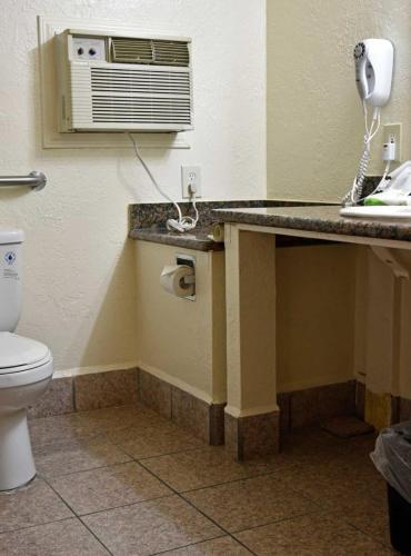 a bathroom with a toilet and a counter with a sink at Monterey Pines Inn in Monterey