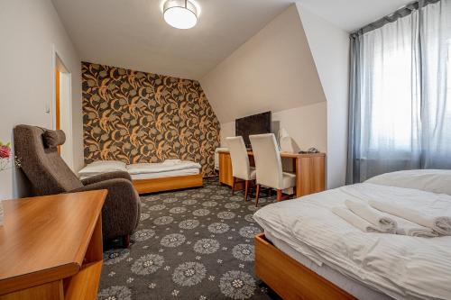 a hotel room with two beds and a desk at City Hotel in Piešťany
