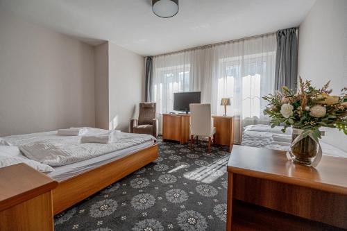 ピエシュチャニにあるCity Hotelのベッドとデスクが備わるホテルルームです。
