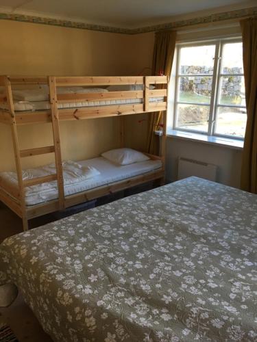 1 Schlafzimmer mit 2 Etagenbetten neben einem Fenster in der Unterkunft Tättas stuga på Malingsbo Herrgård in Malingsbo