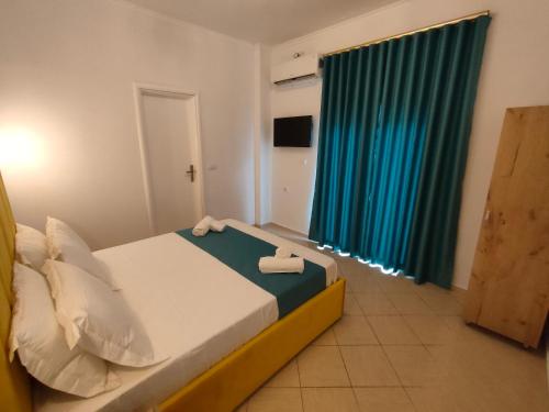 a bedroom with a bed with two towels on it at Vila Bello in Ksamil