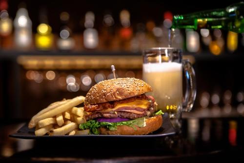 a plate with a hamburger and french fries and a glass of milk at InHouse Hotel Culiacán in Culiacán