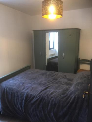 ein Schlafzimmer mit einem großen Bett mit einer blauen Decke in der Unterkunft Maison 5 pièces dans hameau pittoresque très calme in Payrac