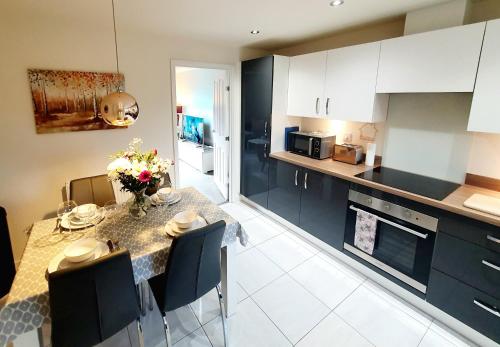 uma cozinha e sala de jantar com mesa e cadeiras em Meadow View, luxury home in heart of England em Shirebrook