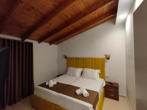 a bedroom with a large bed with a wooden headboard at Vila Bello in Ksamil