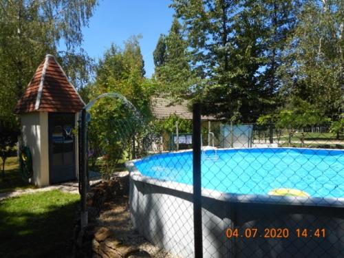 a swimming pool in a yard with a fence around it at Camping Les Arbois in Montjay
