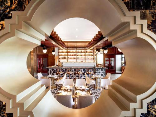 a view of a restaurant with a large round mirror at Avista Grande Phuket Karon - MGallery in Karon Beach