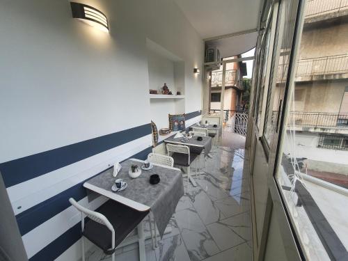 a restaurant with tables and chairs and a balcony at GioRi in Giardini Naxos